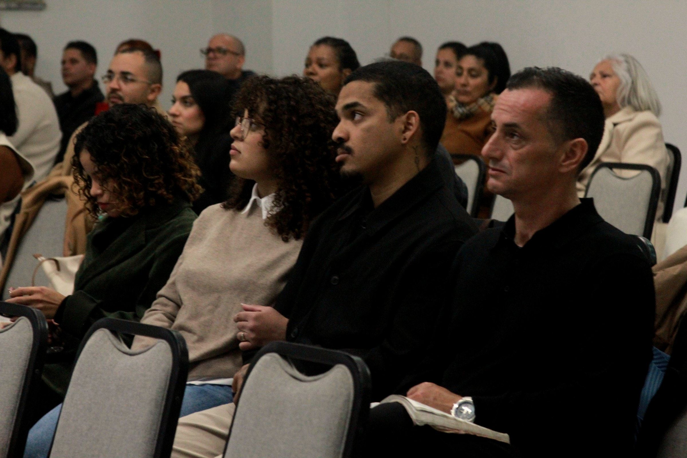 Pessoas sentadas durante o culto, no salão